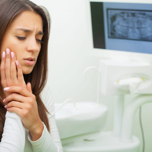 Young female having toothache. Upset woman at the dentist. Constant pulsating pain.